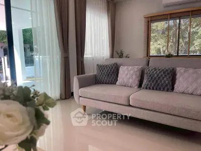 Elegant living room with modern sofa and large windows offering natural light.