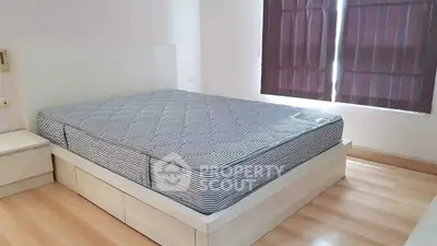 Spacious bedroom with modern bed and natural light, perfect for relaxation.