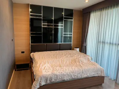 Modern bedroom with large window and stylish decor in a luxury apartment.