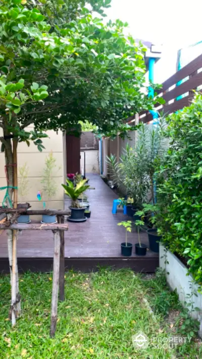 Charming garden pathway with lush greenery and potted plants in a serene residential setting.