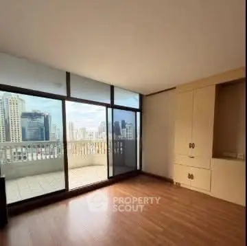 Spacious living room with large windows and city view balcony