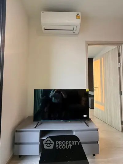 Modern living room with air conditioning and sleek TV setup, perfect for cozy entertainment.