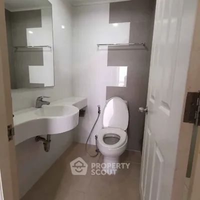 Modern bathroom with sleek fixtures and neutral tones, featuring a stylish sink and toilet.