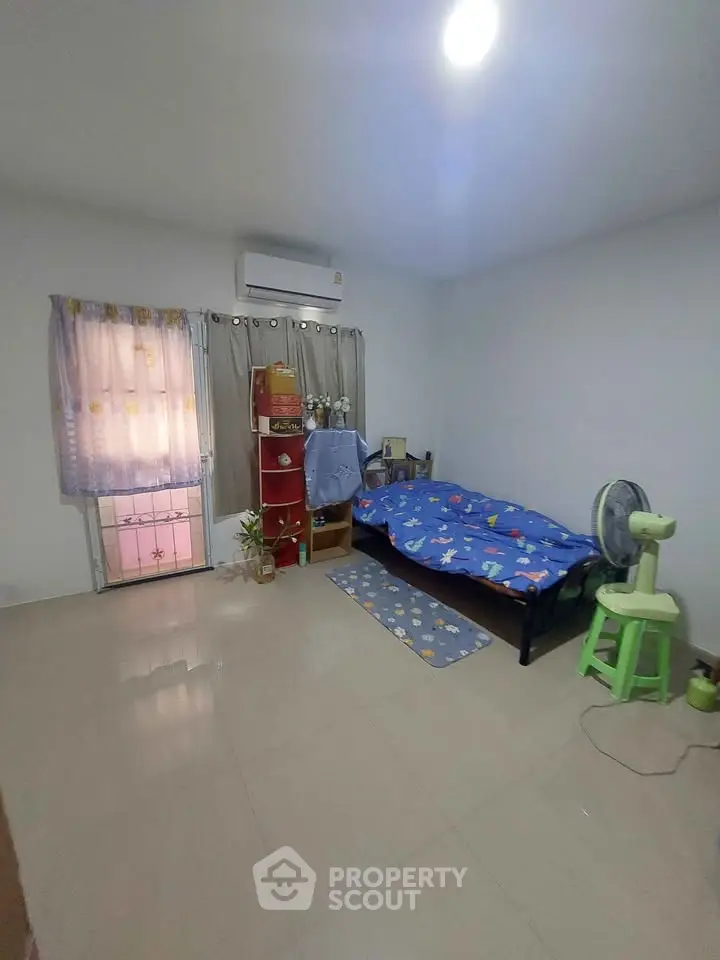 Cozy bedroom with single bed, air conditioning, and minimalist decor