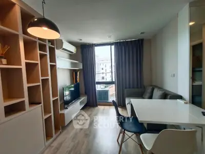 Modern living room with stylish furniture and large window offering city view