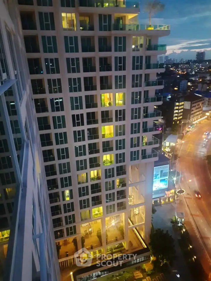 Stunning high-rise building with illuminated windows and cityscape view at dusk.