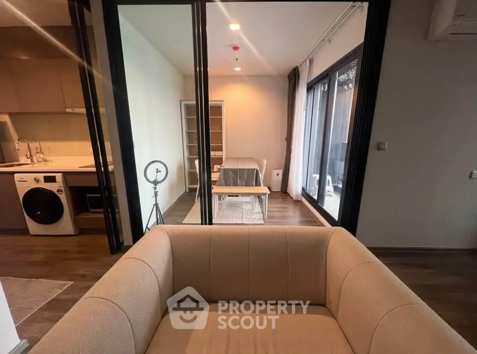 Modern open-plan living room with stylish furniture and large windows for natural light.