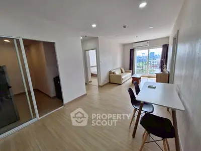 Spacious modern living room with dining area and city view, perfect for urban living.