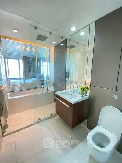 Modern bathroom with glass shower and sleek fixtures in luxury apartment.
