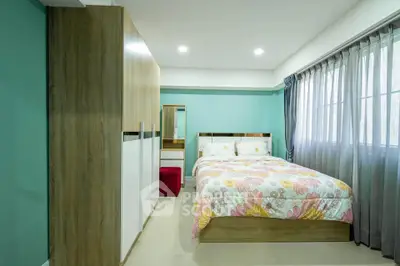 Spacious bedroom with modern decor and large window for natural light