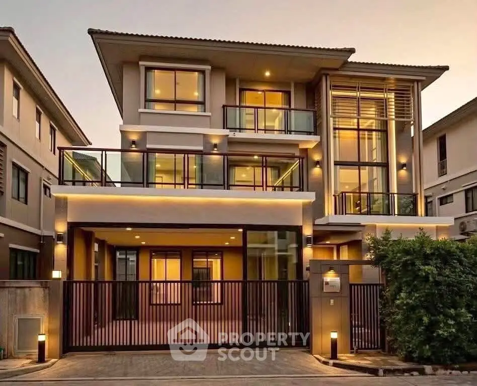 Luxurious modern three-story house with elegant lighting and spacious balconies.