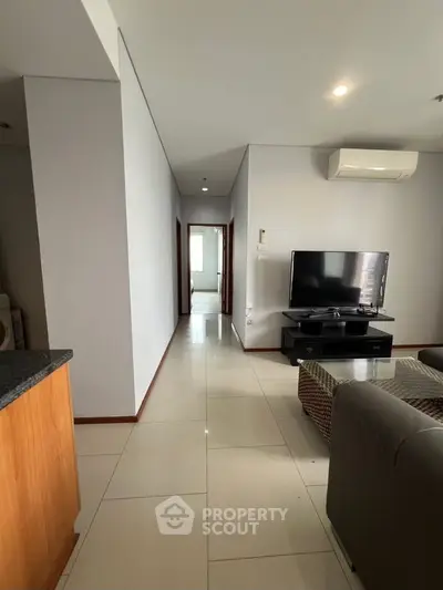 Spacious living room with modern decor and sleek TV setup in a contemporary apartment.