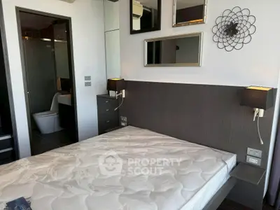 Modern bedroom with stylish decor and ensuite bathroom, featuring elegant lighting and mirrors.