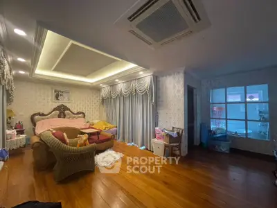Spacious bedroom with elegant decor and wooden flooring