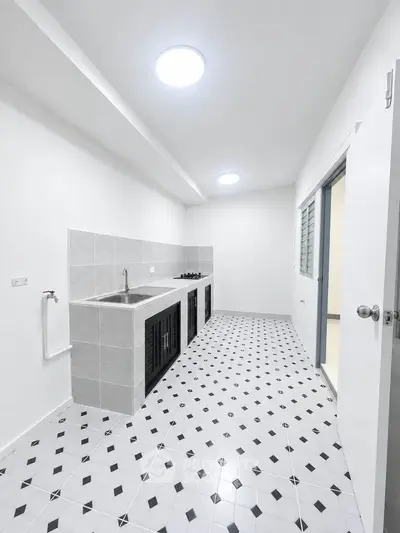 Modern kitchen with sleek design and tiled flooring, featuring a gas stove and ample counter space.