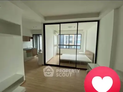Modern studio apartment with open layout and large windows for natural light.
