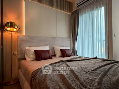 Luxurious bedroom with modern decor and large window offering natural light.