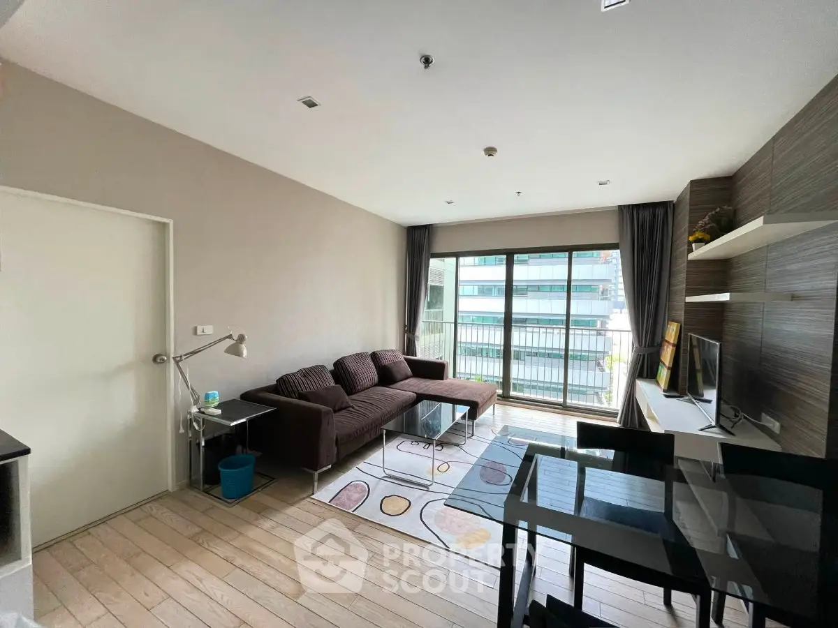Modern living room with large windows and stylish furniture in a bright apartment.