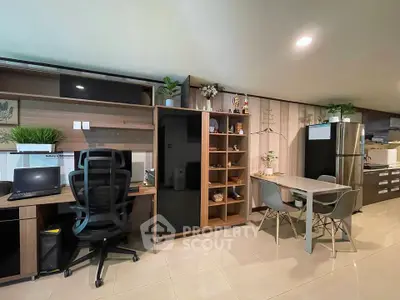 Modern open-plan living space with office area and dining set, featuring sleek furniture and decor.