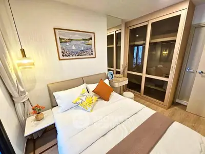 Cozy bedroom with modern decor, featuring a comfortable bed, stylish lighting, and ample closet space.