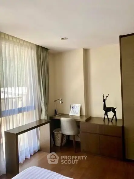 Elegant study area with natural light, featuring a sleek desk and stylish decor in a modern apartment.