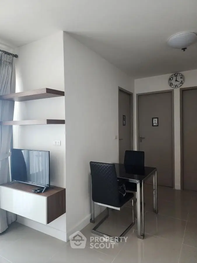 Modern apartment interior with sleek dining area and wall-mounted TV