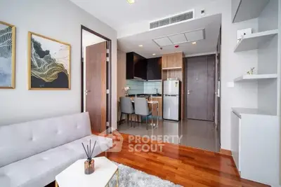 Modern living room with open kitchen, wooden flooring, and stylish decor in a contemporary apartment.
