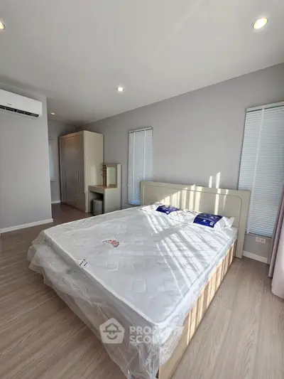 Spacious bedroom with modern design and natural light, featuring a comfortable bed and sleek wardrobe.