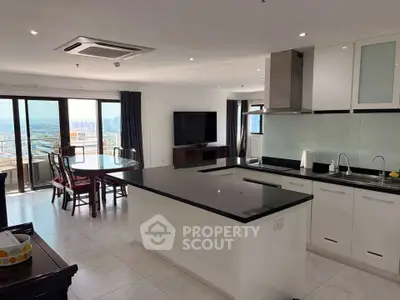 Spacious open-layout kitchen and living room with city view, modern appliances, and elegant dining area.