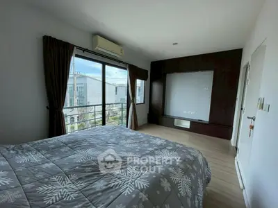 Spacious bedroom with large window and modern decor