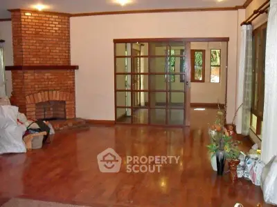 Spacious living room with hardwood floors and brick fireplace