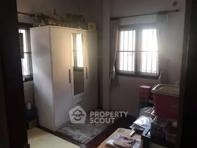 Cozy bedroom with wardrobe and natural light through windows