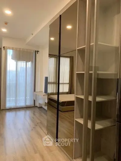 Modern bedroom with mirrored wardrobe and large window for natural light