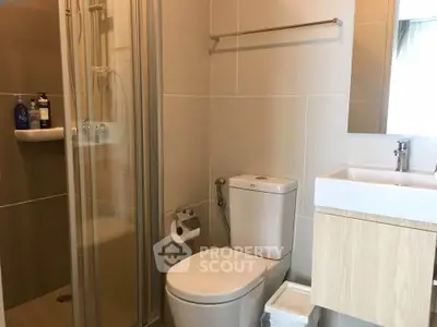 Modern bathroom with glass shower and sleek fixtures in a contemporary apartment.