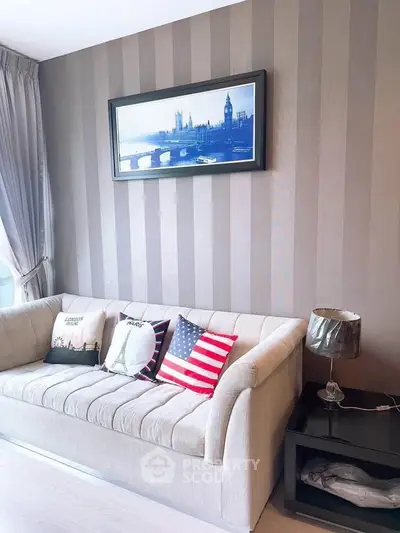 Stylish living room with modern sofa and decorative pillows, featuring elegant wall art and natural light.