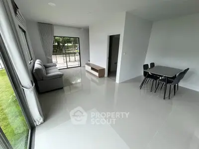 Spacious modern living room with large windows and dining area