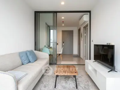 Modern living room with sleek furniture and glass partition in a stylish apartment.