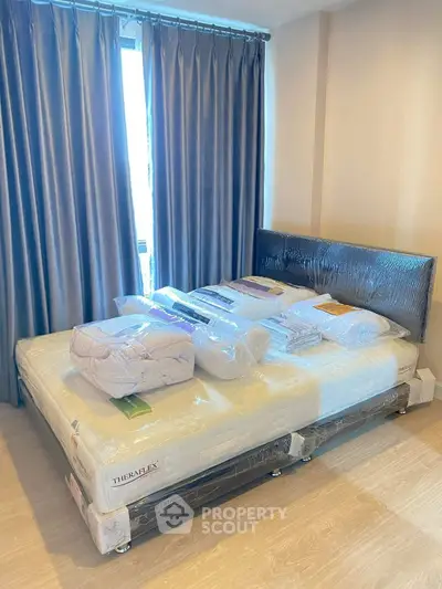 Spacious bedroom with new mattress and elegant curtains in modern apartment