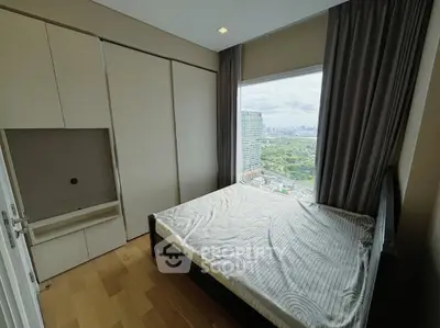 Cozy bedroom with large window offering stunning cityscape views and ample natural light.