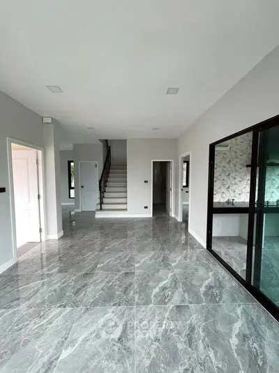 Spacious modern living room with elegant marble flooring and staircase