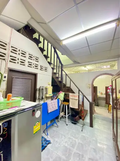 Charming interior with staircase and kitchen area, featuring unique architectural elements and cozy atmosphere.