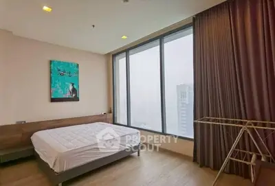 Modern bedroom with large window and city view, featuring minimalist decor and wooden flooring.