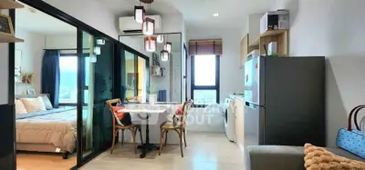 Modern apartment interior with open layout, featuring a cozy dining area and a view into the bedroom.