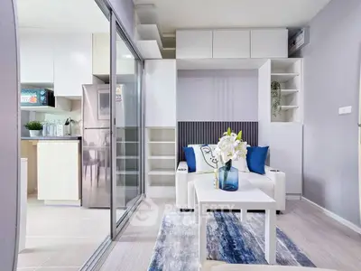 Modern living room with open kitchen, stylish decor, and natural light.