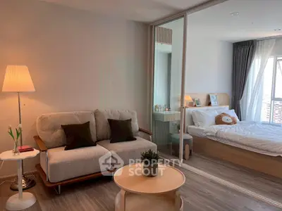 Modern studio apartment with cozy living area and bedroom, featuring stylish decor and natural light.