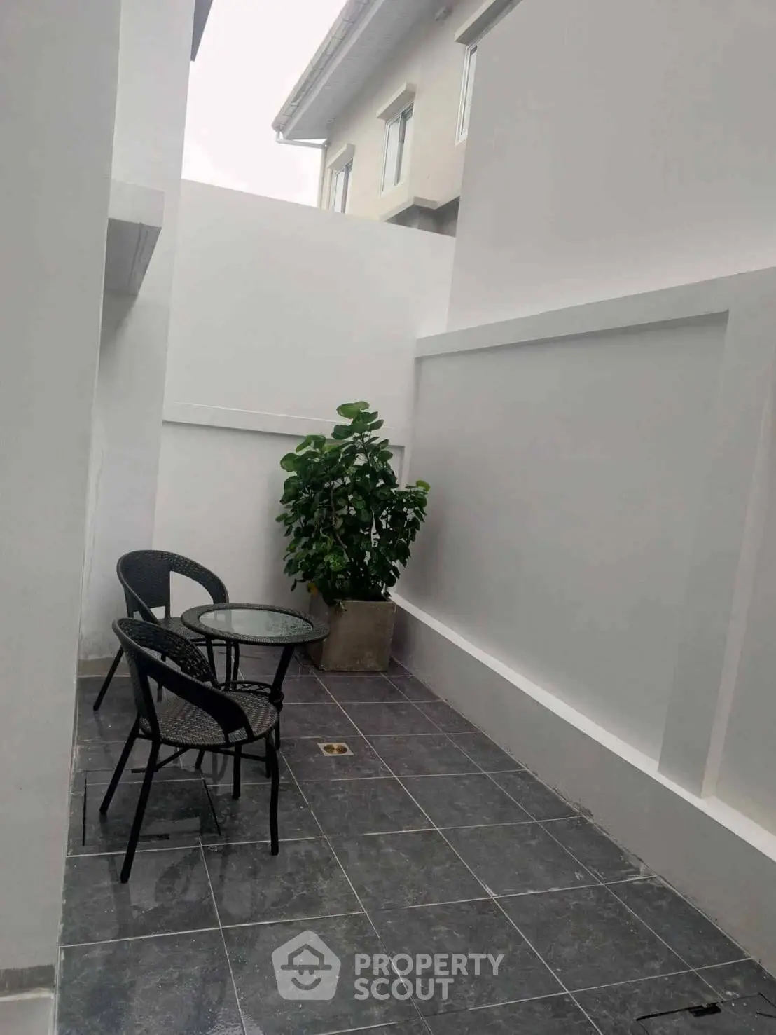 Charming outdoor patio with modern seating and lush greenery, perfect for relaxation and entertaining.