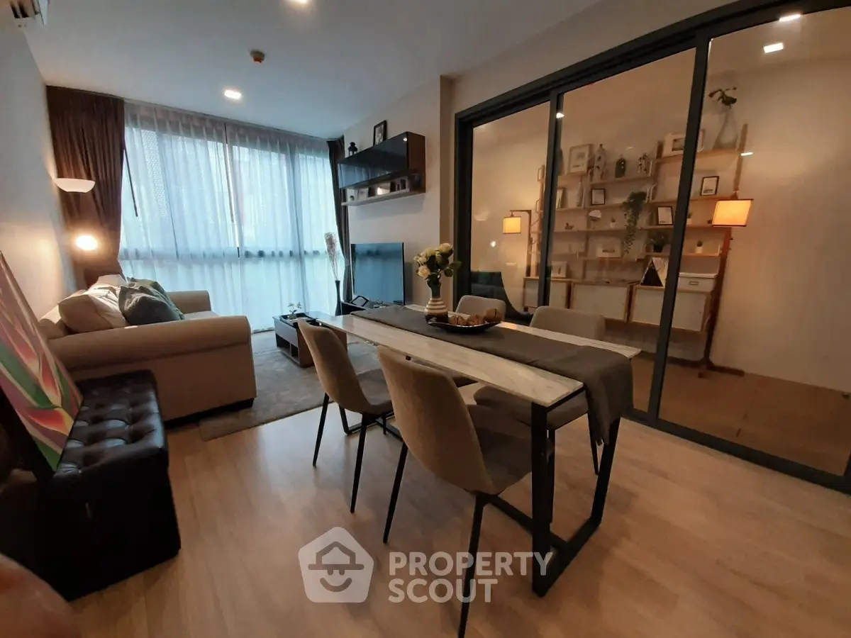 Modern living room with stylish decor and open layout, featuring a cozy seating area and dining table.