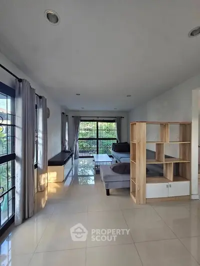 Spacious living room with modern furniture and large windows offering natural light.