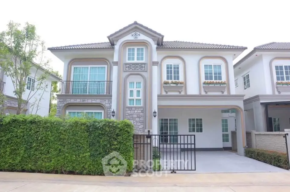 Elegant two-story house with classic architecture and lush greenery in a serene neighborhood.