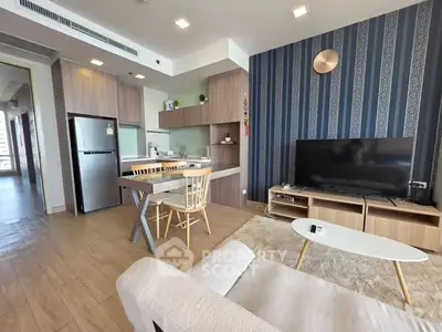 Modern open-plan living room with stylish kitchen and cozy seating area, perfect for contemporary living.